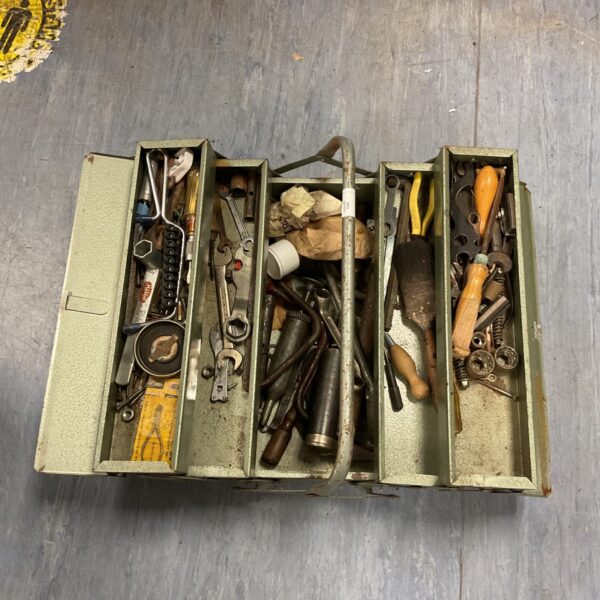 Vintage cantilever toolbox filled with antique tools for workshop storage.