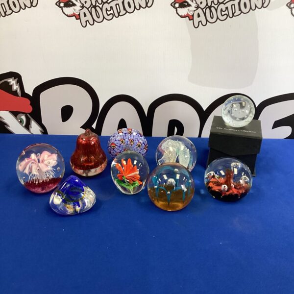 Colourful glass paperweight collection for desk or display.