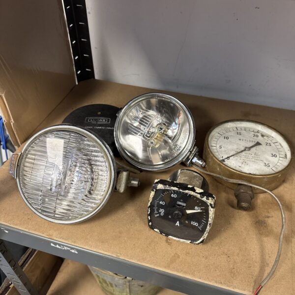 Vintage Lucas gauges and spotlamps lot for classic car restoration.