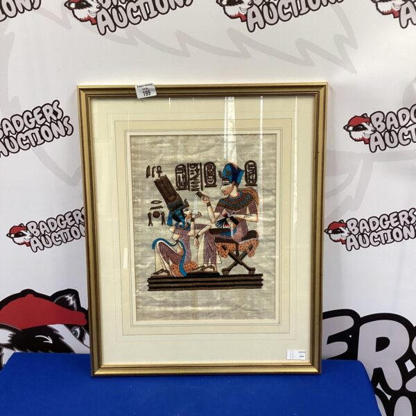 Framed Egyptian papyrus art with a gilt frame, depicting ancient figures.