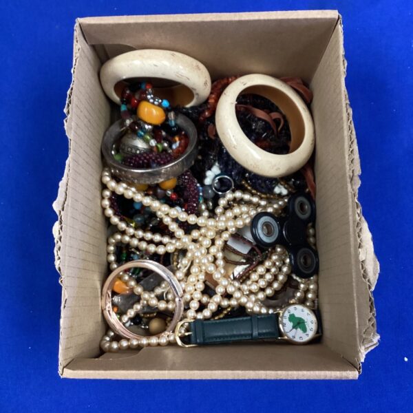Mixed jewellery lot with colourful beads and vintage brooches.