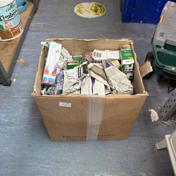 Mixed lot of new light bulbs in a cardboard box.