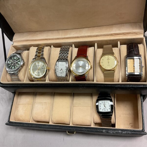 Vintage wristwatch lot displayed in a leather case.