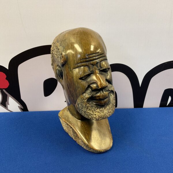 Hand-carved African tribal elder bust, detailed stone sculpture.
