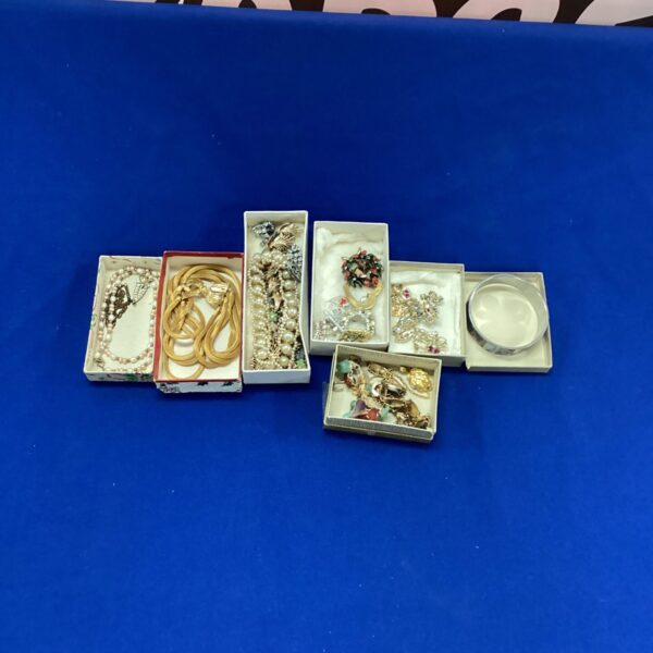 Costume jewellery assortment featuring pearl necklace and brooch.