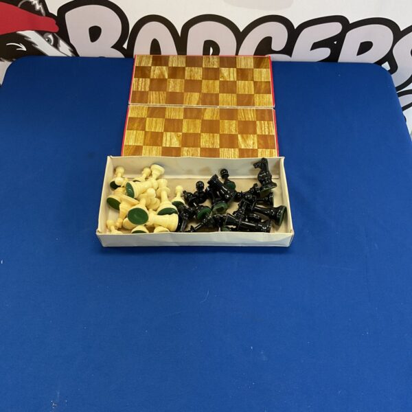 Vintage folding chess set with plastic pieces on a checkered board.