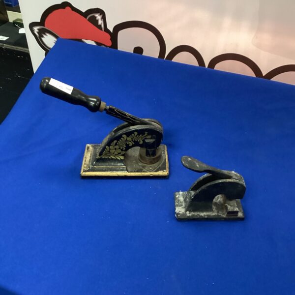 Antique cast iron embossing device with handle and detailed design.