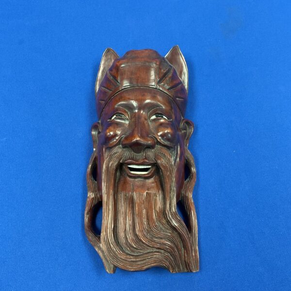 Intricate vintage Chinese carved mask with detailed beard.