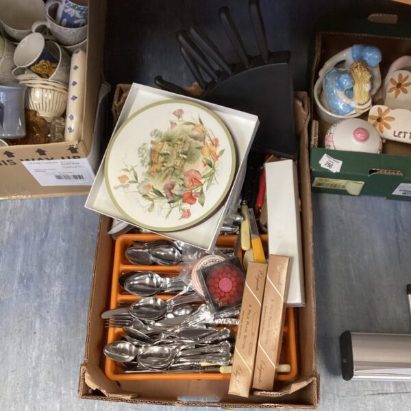 Mixed kitchen lot featuring stainless steel cutlery and patterned plates.