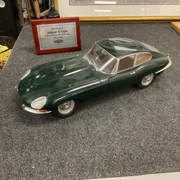 Green Jaguar E-type model car on display.
