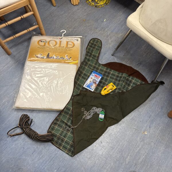 Green tartan dog coat with leads and cushion.