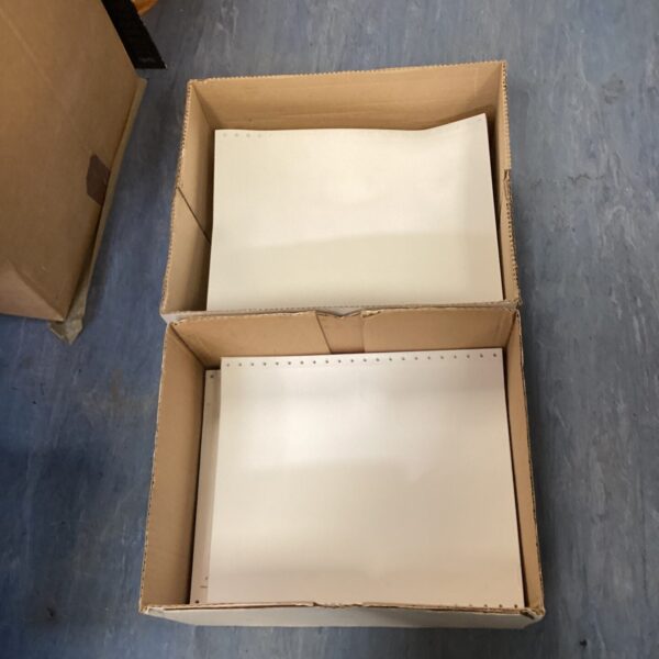 Two boxes of vintage dot matrix printer paper for retro computers.