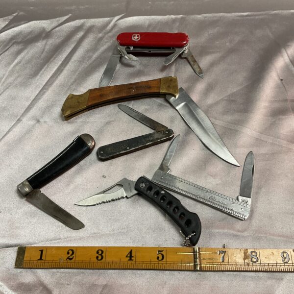Assorted vintage pocket knives including a Victorinox multi-tool.