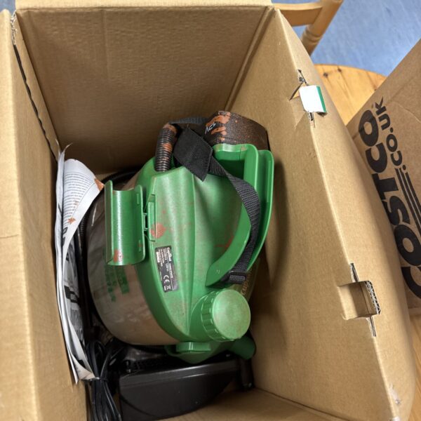 Cuprinol power sprayer in garden setting, handheld battery tool.
