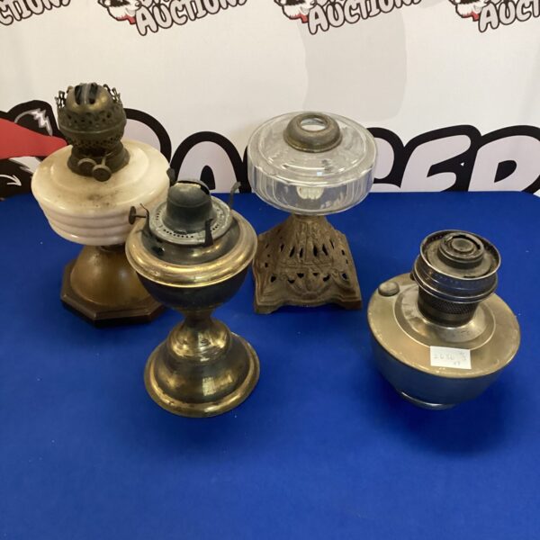 Collection of four vintage oil lamps with glass shades.