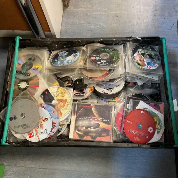 Assorted DVD and Blu-ray discs in a crate for home entertainment.