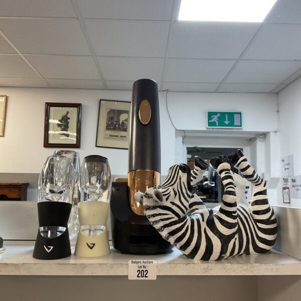 Wine aerator, Cuisinart corkscrew, and zebra bottle holder set on display.