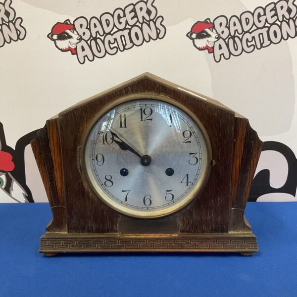 Vintage art deco mantle clock with pale wood case and clear face.