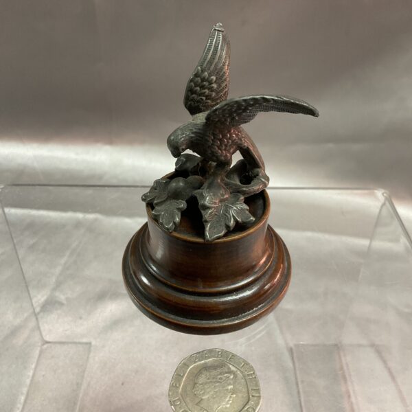 Detailed bronze hawk sculpture on wooden base, vintage collectible.