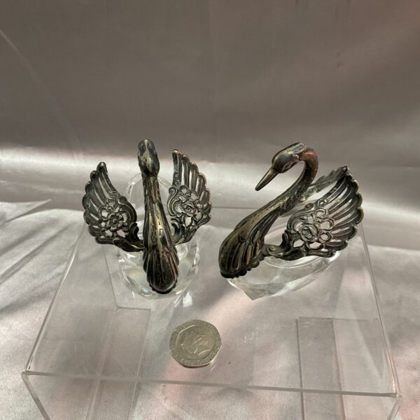 Vintage silver swan trinket dishes on a clear base.