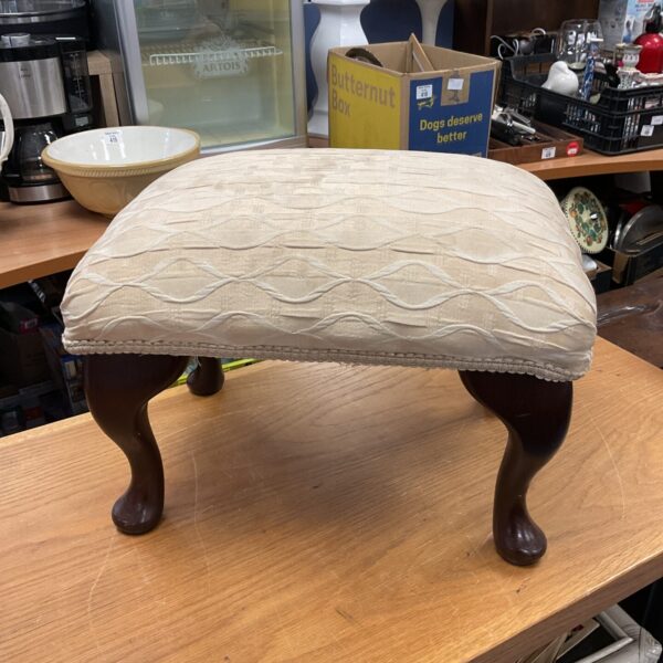 Vintage mahogany footstool with upholstered seat and carved legs.