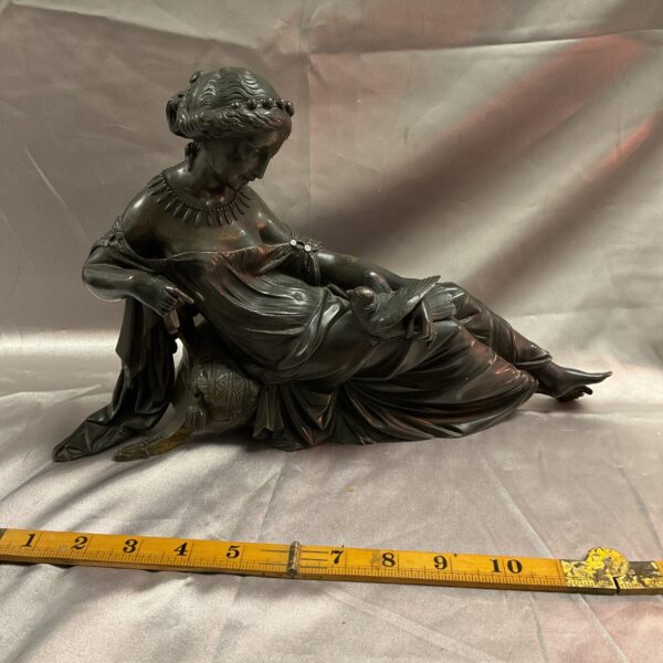 Antique bronze sculpture of seated lady with dove.