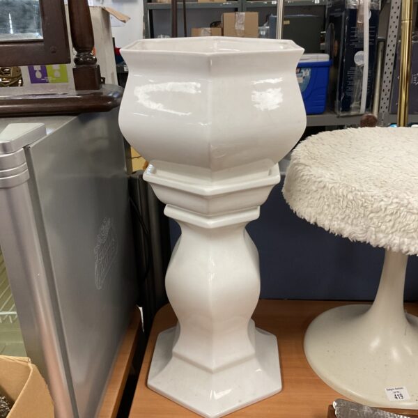 White ceramic jardiniere stand for plant display.