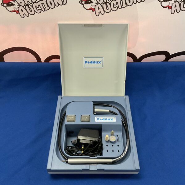 Vintage Pedilux pedicure machine with handheld tool and attachments.