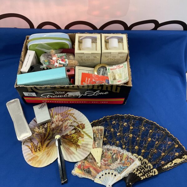 Mixed lot of vintage hand fans and battery candles for home decor.