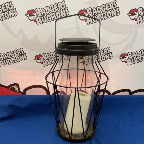Large metal candle lantern with clear glass holder for warm ambiance.