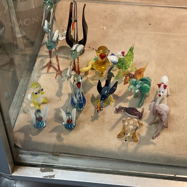 Colourful glass animal and bird figurines on display.