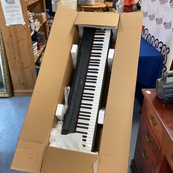 Yamaha P-115 digital piano in its box, ready for auction.