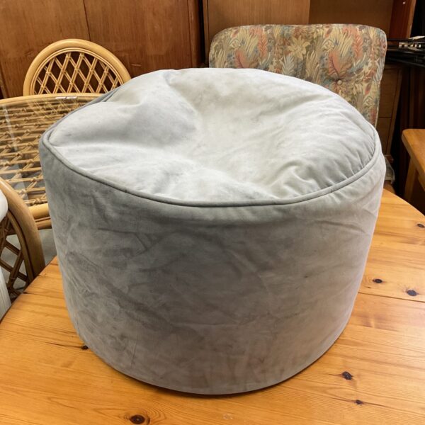 Grey fabric pouffe, side view, modern home decor.