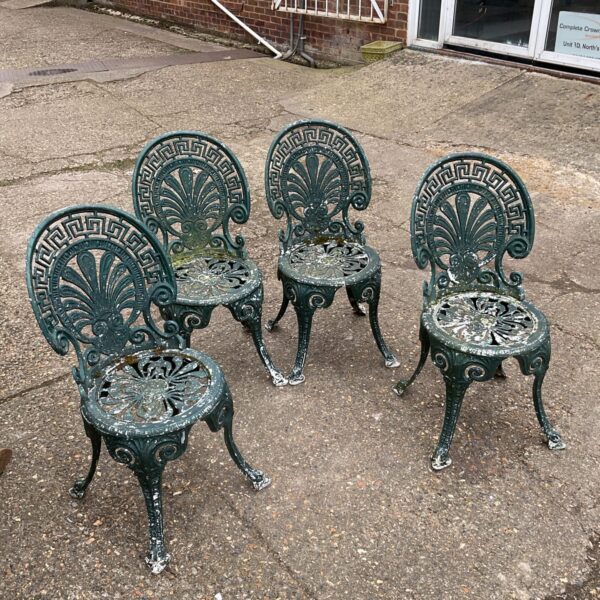 Set of four vintage aluminium garden chairs with ornate detailing.