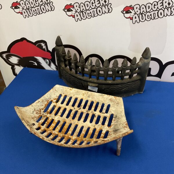 Antique cast iron fireplace grate with arched design.