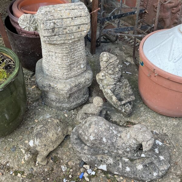 Weathered concrete cherub garden ornament with moss growth.