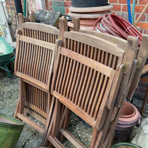 Vintage teak folding garden chairs in a garden setting.