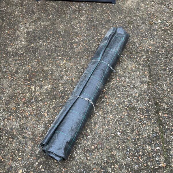 Black weed membrane roll for garden weed control.