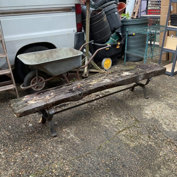Rustic railway sleeper bench in a garden setting.