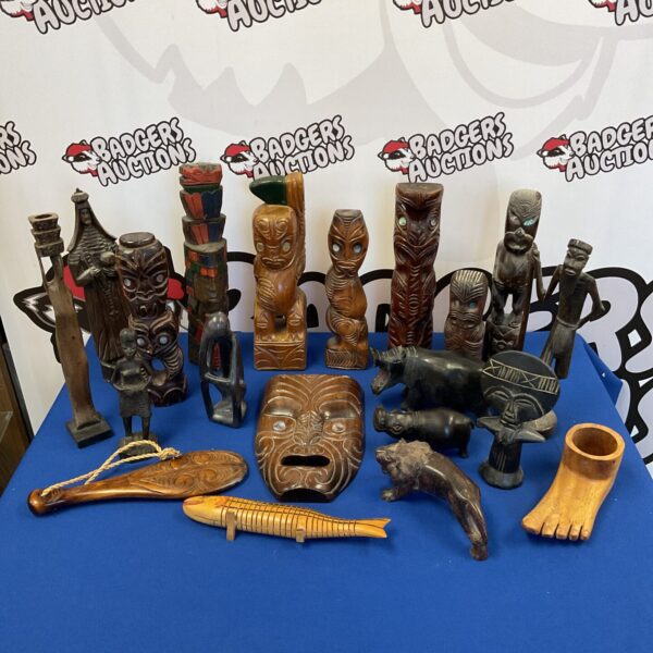 Collection of tribal carved figures and totems on a dark surface.