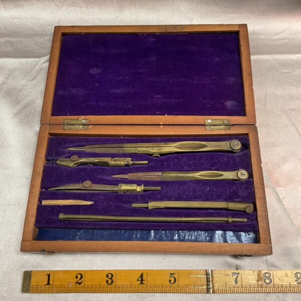 Antique brass drawing instrument set in open case.