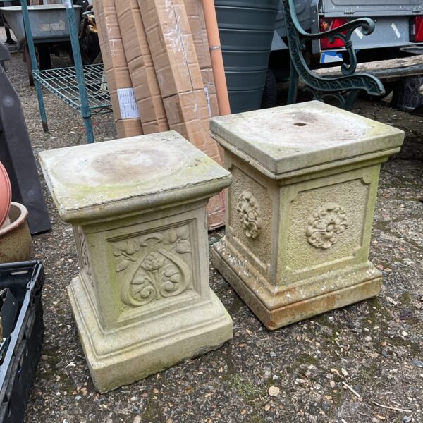 Pair of weathered concrete planter pedestals for garden display.
