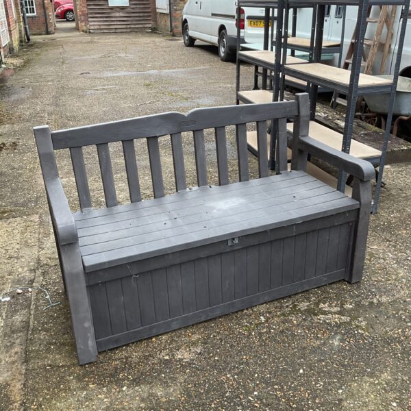 Grey Keter plastic garden storage bench in an outdoor setting.