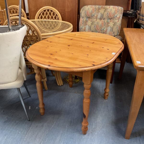 Rustic pine kitchen table with turned legs in a farmhouse setting.