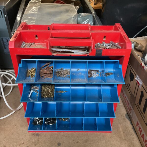 Red portable screw organizer with open drawers showing compartments.