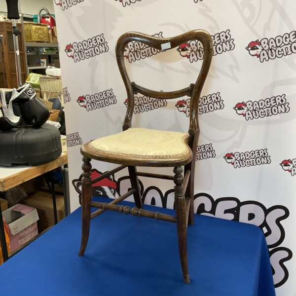 Antique mahogany balloon back chair with elegant design.