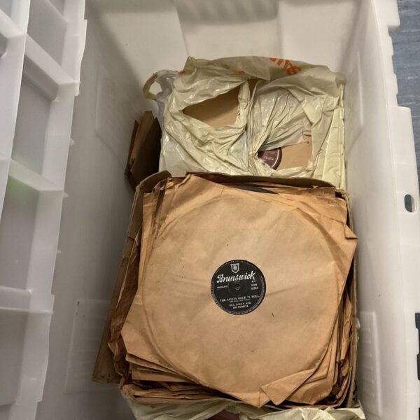 Crate filled with vintage gramophone records for collectors.