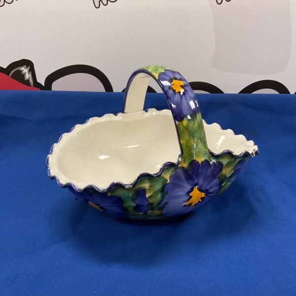 Vibrant handpainted ceramic fruit basket with a looped handle.