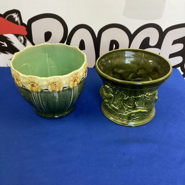 Vintage glazed flower pots with floral design for garden decor.