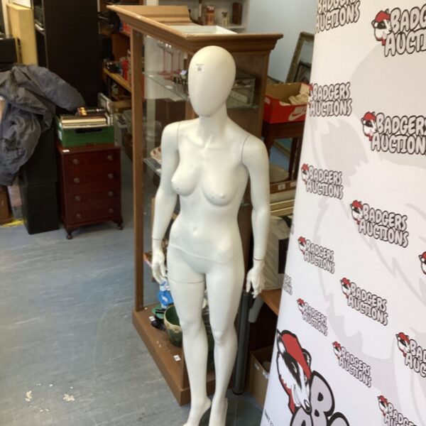 Full size female manikin on display with stand.